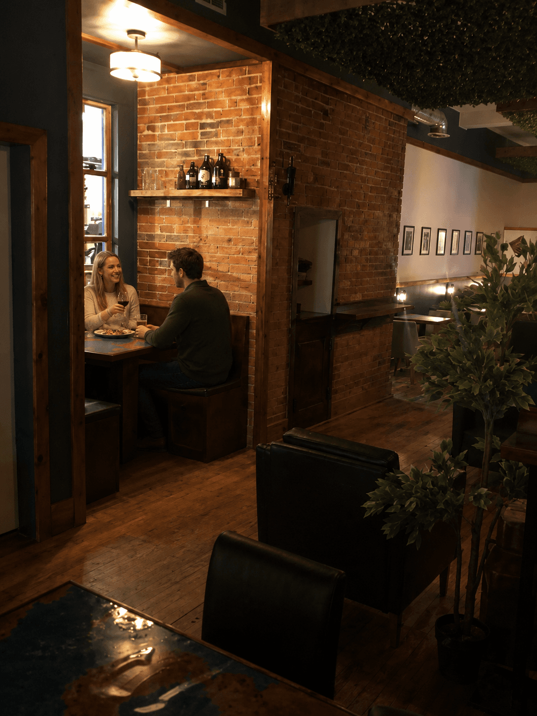 A cozy brick-walled booth at The Neighbourhood Social House